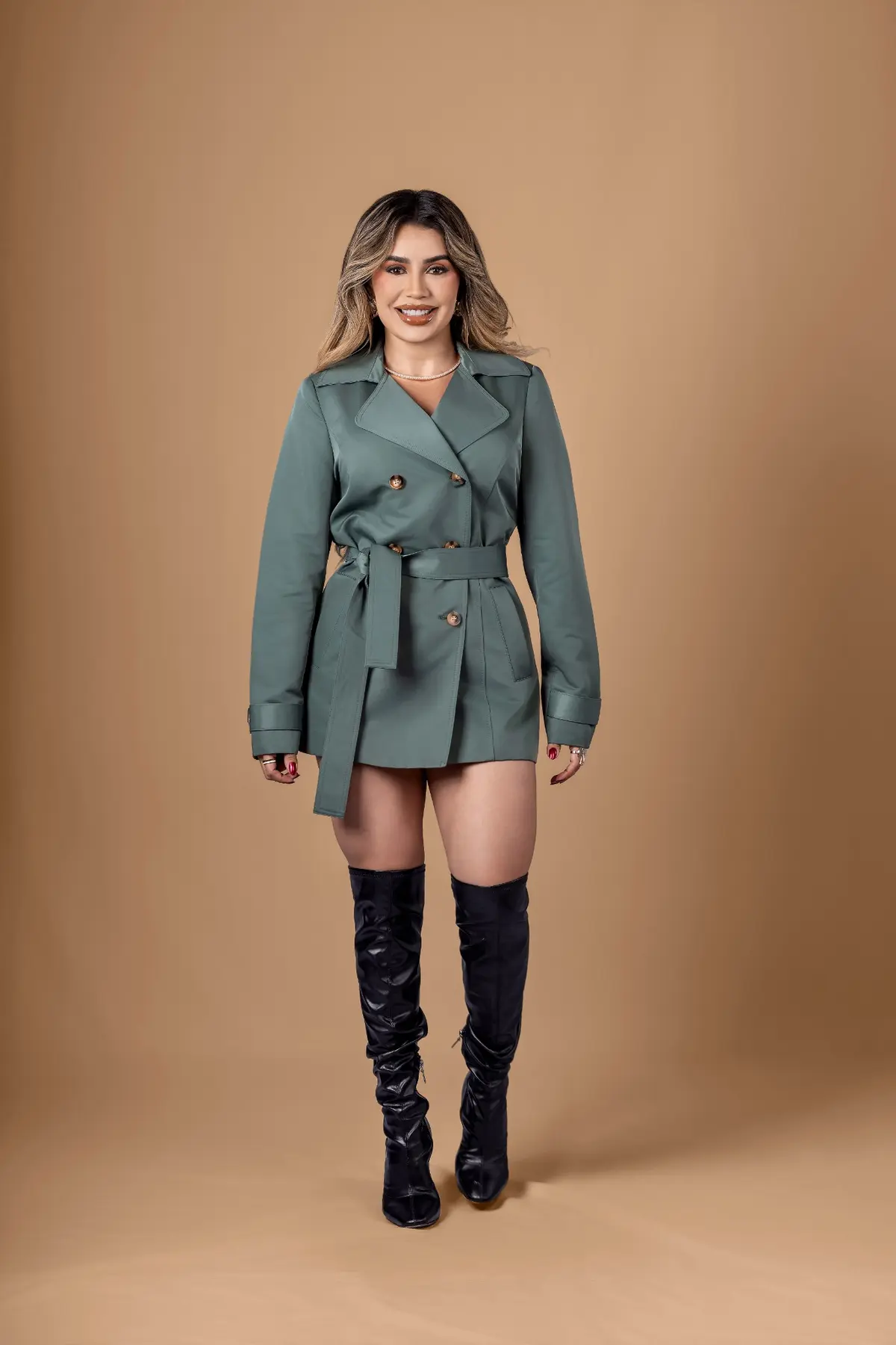 Brisiane em retrato de corpo inteiro com casaco verde e botas pretas